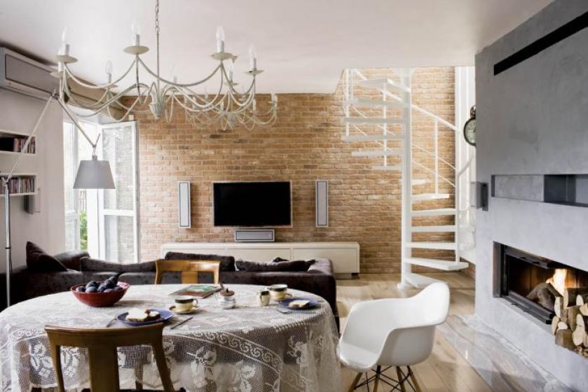 Fragment podłogi przed kominkiem wyłożono onyksem- to łagodne przejście od surowej ściany do ciepłych desek z bielonego dębu.