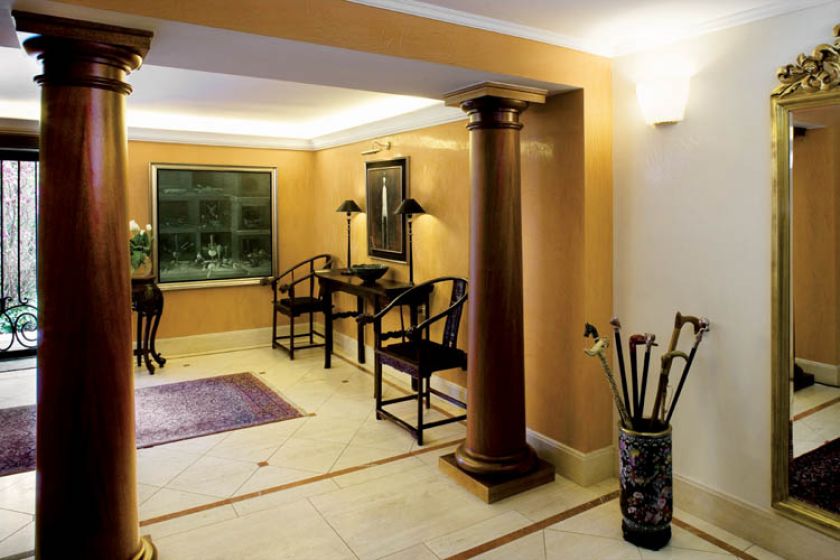 Hol urządzono przywiezionymi z Chin meblami. Stylowym dodatkien jest kolekcja lasek w barwnym pojemniku.