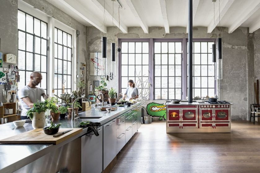 COUNTRY, stylizowany piec w kolorze burgunda, wrzosowe okiennice i dużo roślin, które ocieplają loftowe wnętrze, J. CORRADI.