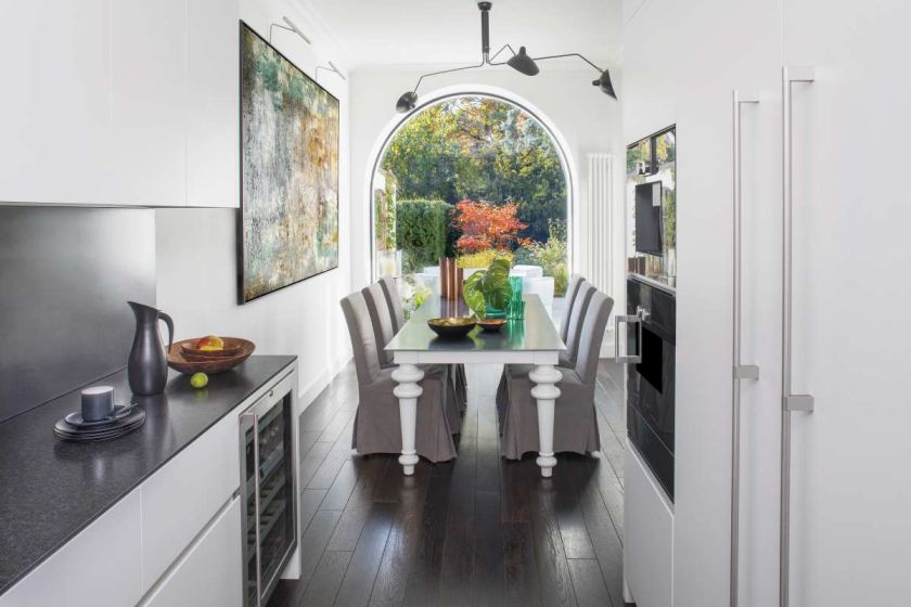 Stół z metalowym blatem – Gervasoni, lampa – Serge Mouille. Drzwi, okna i schody na wzór oryginalnych zrobiła polska