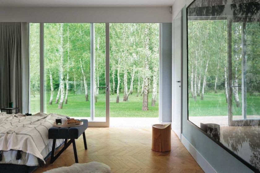 Ten dom w nowoczesnym stylu położony jest wśród brzóz i wygląda pięknie.