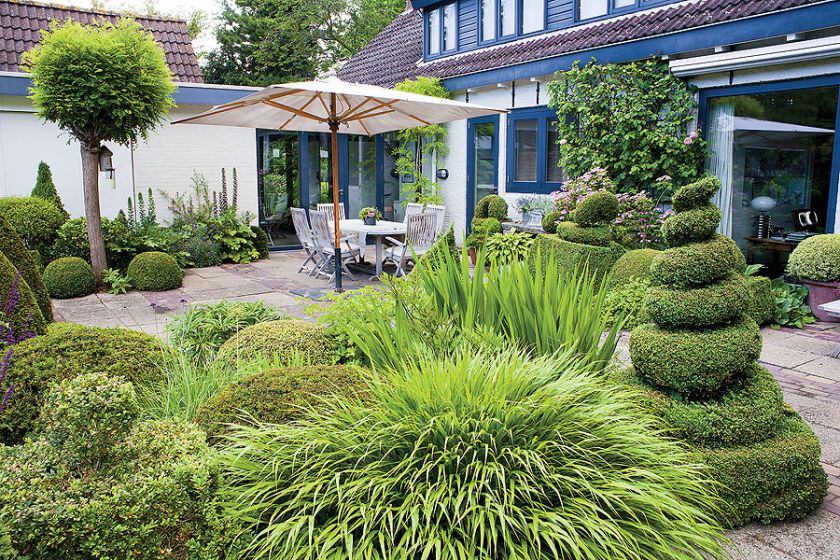 Obok domu taras płynnie wchodzący do ogrodu.