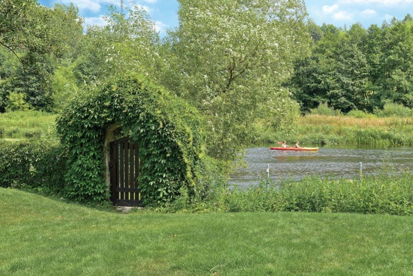 Obrośnięta winobluszczem furtka jest tu od zawsze. Zwieńczeniem trawiastej łąki są nadbrzeżne trzciny i szuwary.