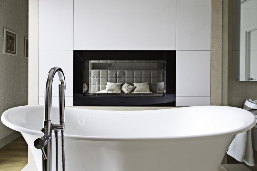 Obustronnie przeszklony biokominek umożliwia kontakt wzrokowy między sypialnią a łazienką.