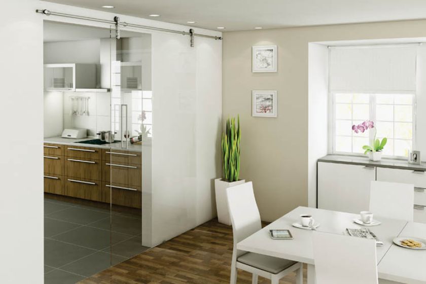 Pomysł do niewielkiego mieszkania - przesuwane szklane drzwi odgradzają kuchnię od jadalni, ale nie zajmują miejsca. HAFELE