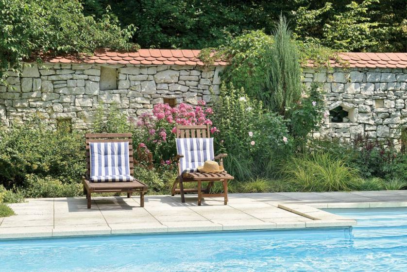 Niewielki basen ukryty jest za grabowym płotkiem.