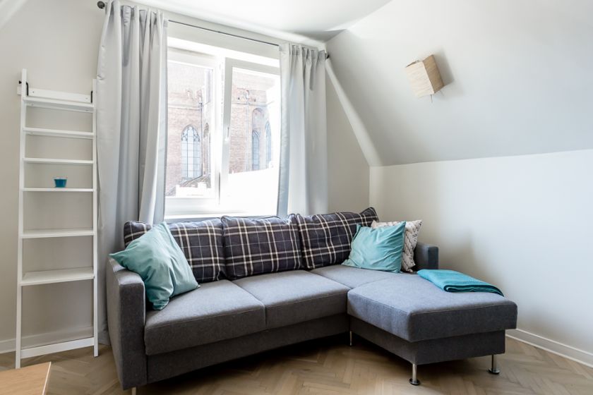 Rozmiar kanapy dobrano tak, by zmieściła się pod oknem. Vis-a-vis znajduje się telewizor.