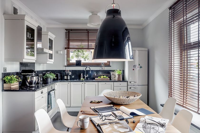 Rozsuwany jednym palcem stół marki Calligaris oraz krzesła Eamesów.