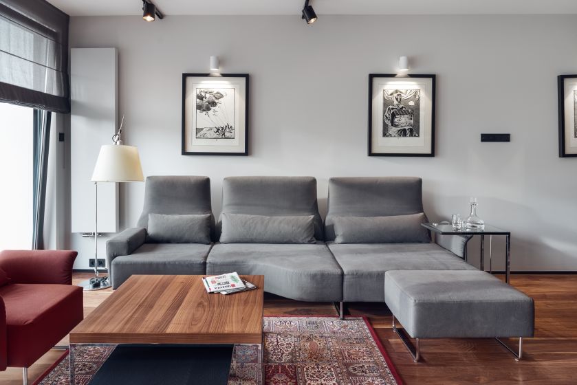 Salon to wielkomiejski eklektyzm: nowoczesna kanapa, modernistyczny stolik, orientalny dywan.