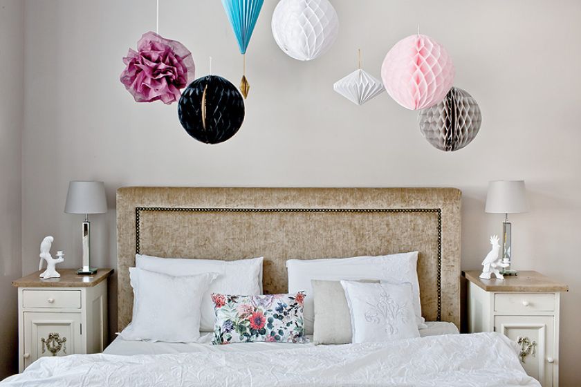 Ściany w perłowym różu i papierowe ozdoby pod sufitem.