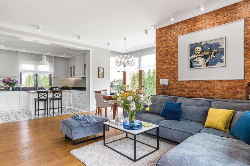 Salon zdobi ściana z cegieł, sypialnię – błękitne motywy. To dom trochę klasyczny, trochę nowoczesny,