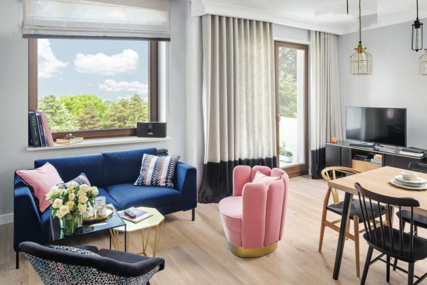 Przy ławie królowa PRL-owskiego wzornictwa - Muszelka Ewa, fotel na nowo tapicerowany tkaniną Christiana Lacroix.