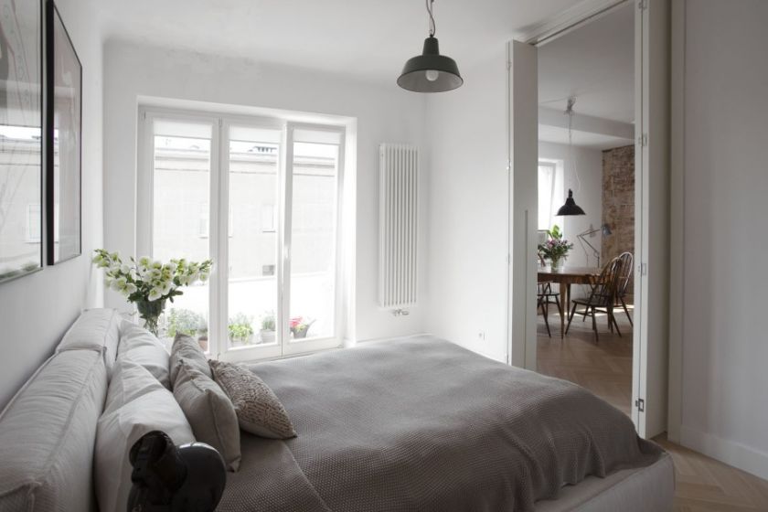 Sypialnia z przejściem do salonu. Jasne mieszkanie bez zbędnych dodatków