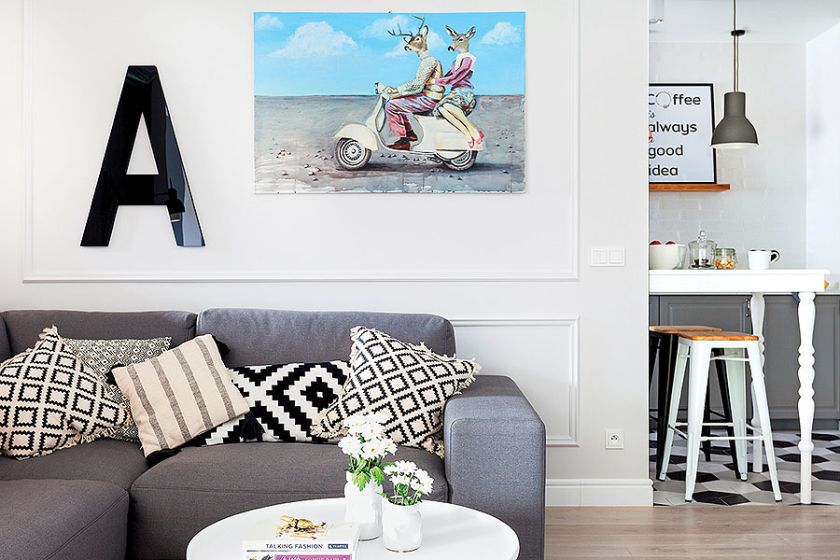 Szarości i biel przełamują pastelowe akcenty dodatków, np. obrazów.