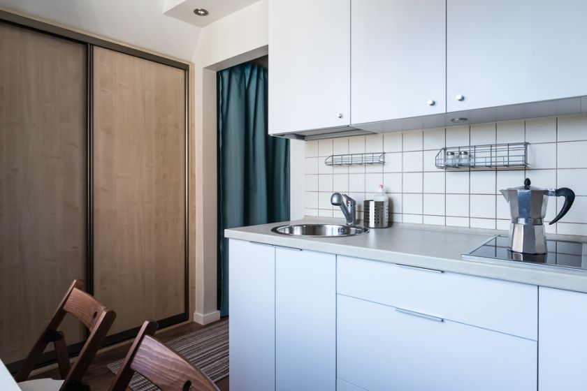 W kuchnio-salono-jadalni zamontowano pojemną szafę z przesuwanymi drzwiami.