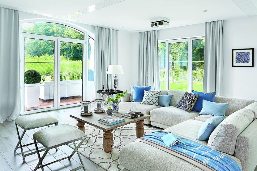 W salonie pledy i błekitne poduchy są z NAPu. Dywan z marokańskim wzorem, stolik-taca i świeczniki to Mint Grey,