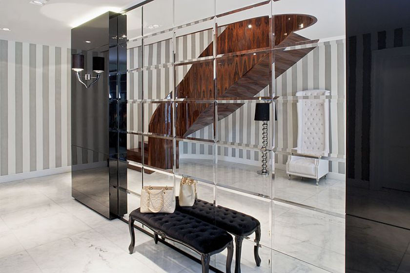 We frezowanych kryształowych lustrach odbija się niezwykła klatka schodowa wyłożona dekoracyjnym fornirem.