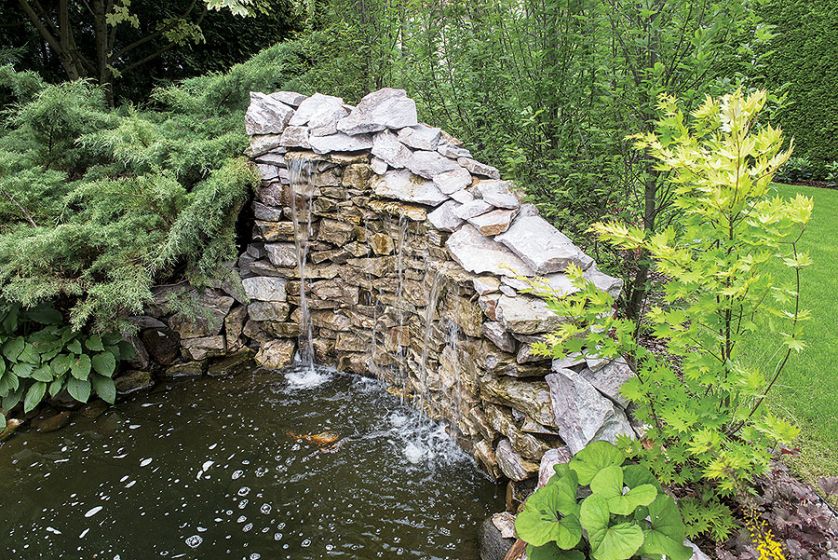 Wodospad, zimozielone krzewy i drzewa, kompozycje w donicach.