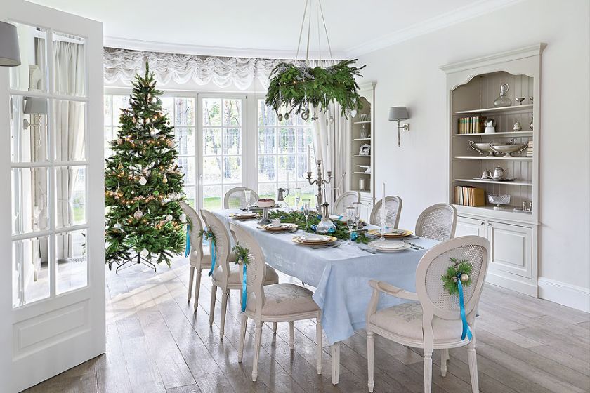 Z jadalni, w której stoi wigilijny stół, widać salon z choinką.