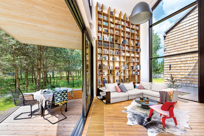 Z salonu jest wyjście na taras. Nowoczesny dom kryty gontem