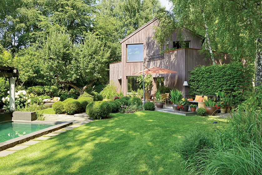 Dom obłożony modrzewiem komponuje się z otaczającą go zielenią.