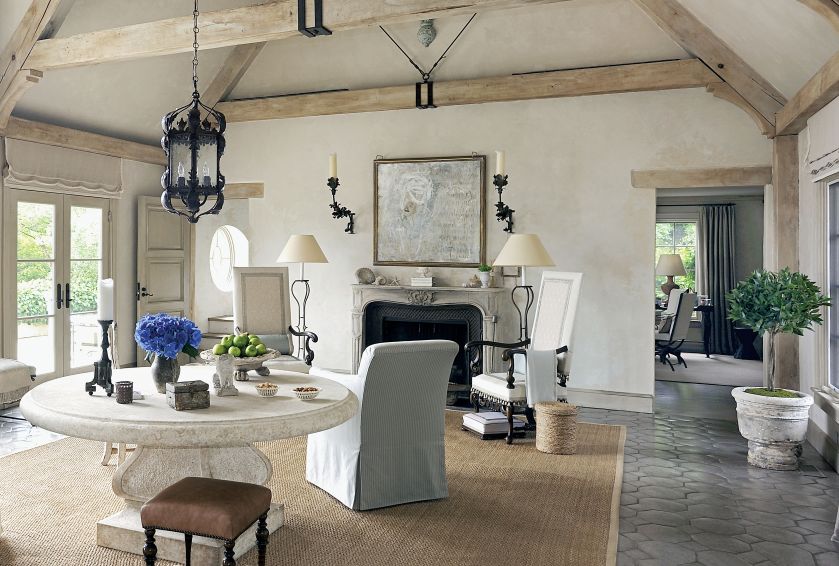 Podłogę w salonie wyłożono marokańskimi płytkami z terakoty, na nich dywan z sizalu. Przy kominku wysokie fotele w stylu