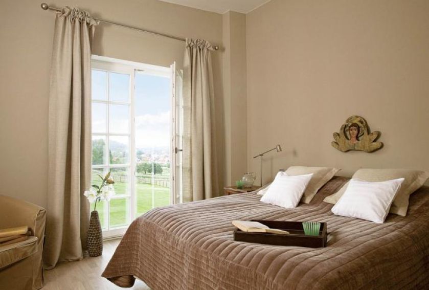 Nad łóżkiem wisi płaskorzeźba przedstawiająca anioła.