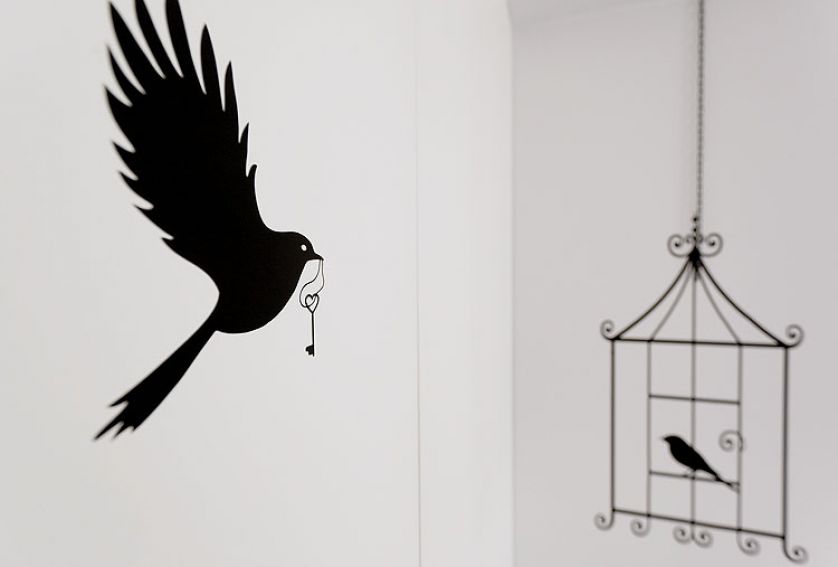 Naklejka z ptaszkiem w klatce zamówiona przez internet i zestawiona z metalowym łańcuszkiem.