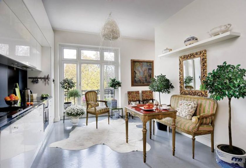 Intrygujące zestawienie: nowoczesna, oszczędna kuchnia- meble i lustro jak z pałacu. A na podłodze klepka