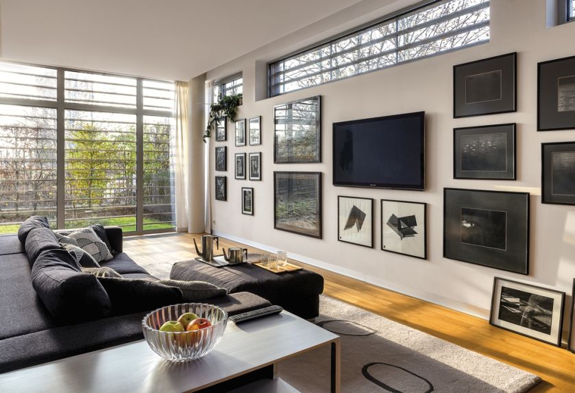 Dobry pomysł na ukrycie telewizora wśród artystycznej kolekcji. Na ścianie wiszą prace Ryszarda Winiarskiego, Mikołaja