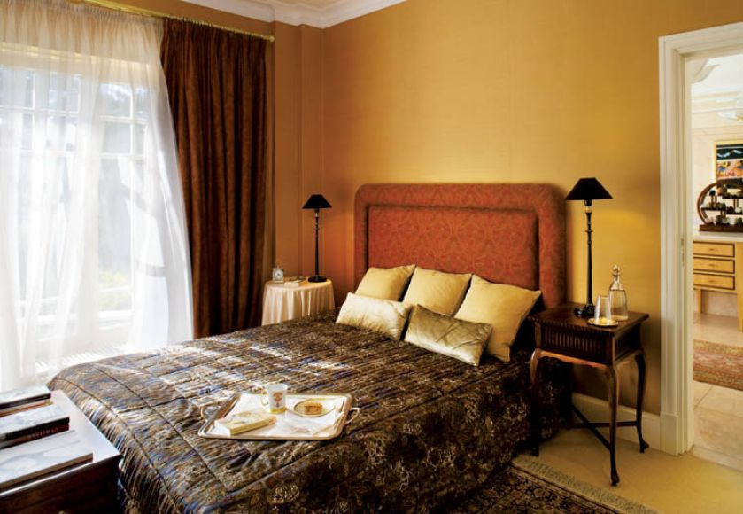 W sypialni proste meble. Głowną ozdobą są wzorzyste tkaniny, które dodają przytulności.