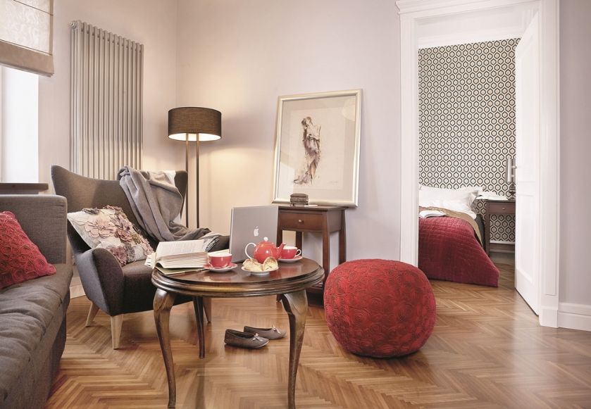 Czerwony puf przełamuje szarości we wnętrzu.