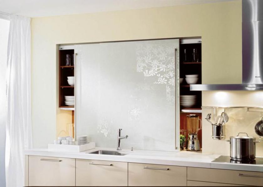 Kolekcja Activ/Systemat - naczynia sprytnie ukryto za przesuwaną taflą szkła z białym nadrukiem kwiatowym. HAECKER