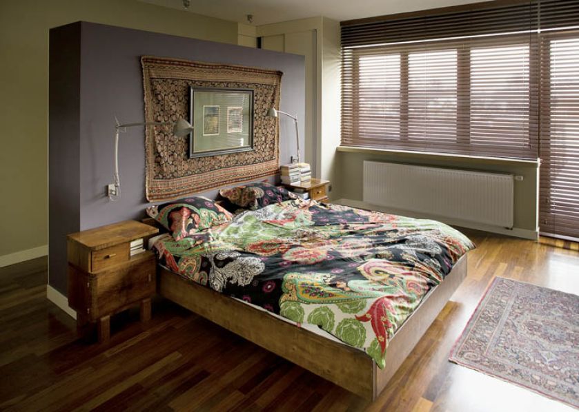Drewniane, solidne łóżko i bajecznie kolorowa pościel.