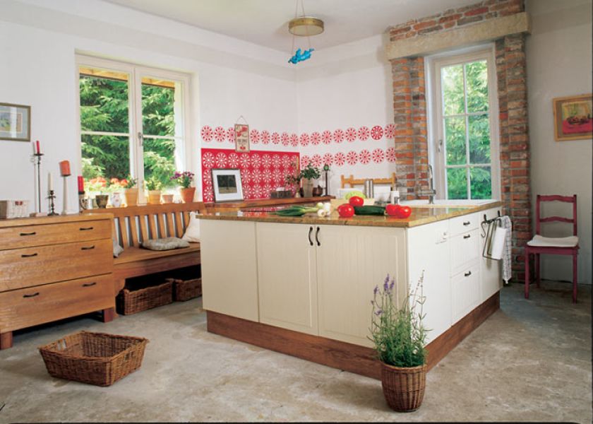 Czerwone wzory na kuchennej ścianie przypominają ludowe wycinanki. To naklejki z samoprzylepnej folii.