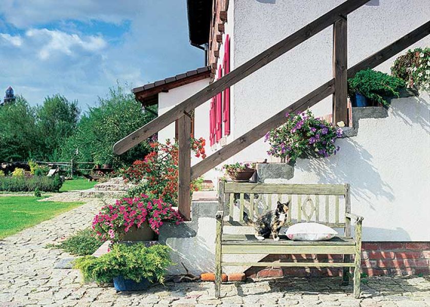 Surowy beton schodów i stara, drewniana ławka też mogą być ozdobą.