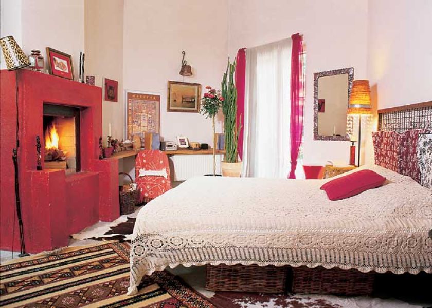 W sypialni stylistyczny miszmasz, ale wszstko spina energetyczna czerwień.