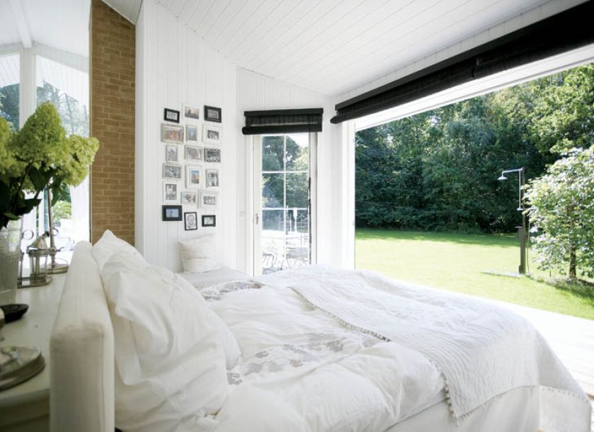 Szklana ściana sprawia, że ogród zdaje się wdzierać do wnętrza.