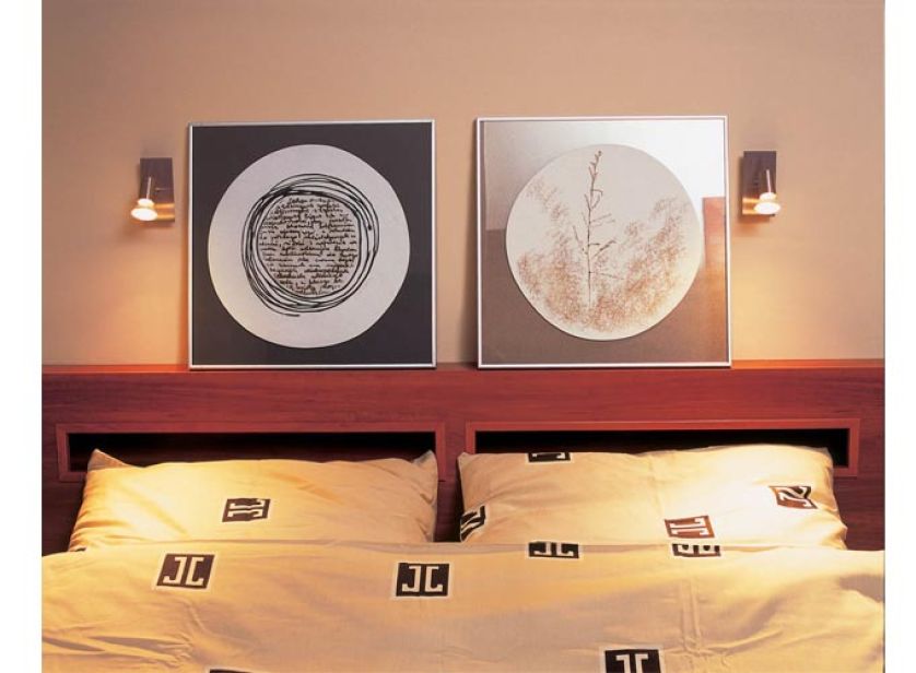 Nad łóżkiem stoją ciekawe obrazki. Porcelanowy dom