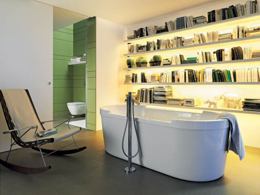 Wanna i bateria wolno stojąca zaprojektowane przez Starcka na tle komowej biblioteki. DURAVIT