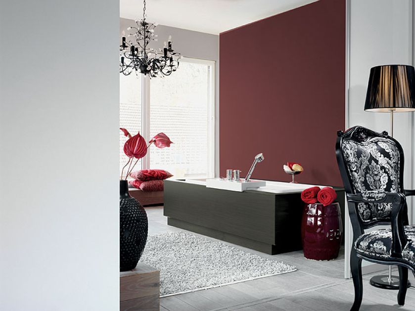 Jedna ściana w kolorze burgunda, pozostałe bladoszare. To propozycja do łazienki marki CAPAROL.