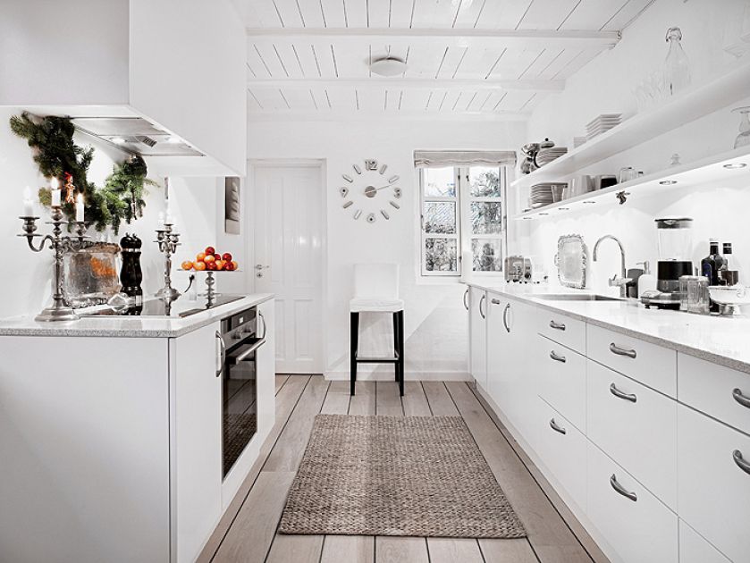 Proste białe meble i drewniane deski na podłodze - typowy styl skandynawski.