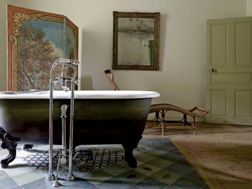 W łazience znajdziemy wolnostojącą wannę na zdobionych nóżkach.