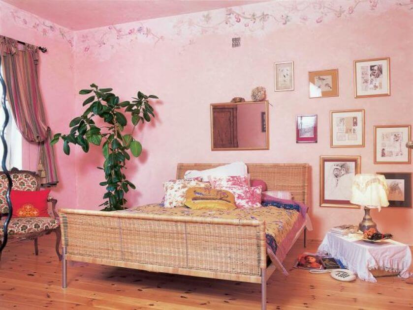 W sypialni stoi duże wiklinowe łóżko.