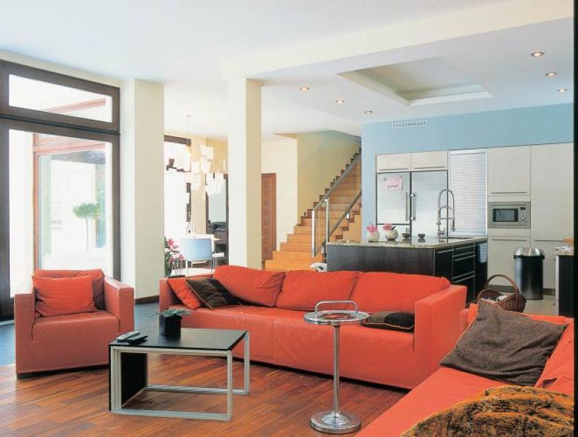 W salonie czerwone kanapy. Modernistyczna willa w stolicy