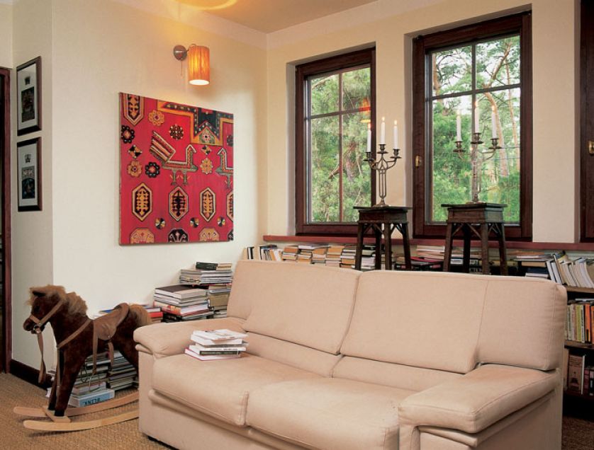 Rodzinne miejsce do wypoczynku - książki, koń na biegunach, na ścianie obraz Olgi Wolniak.