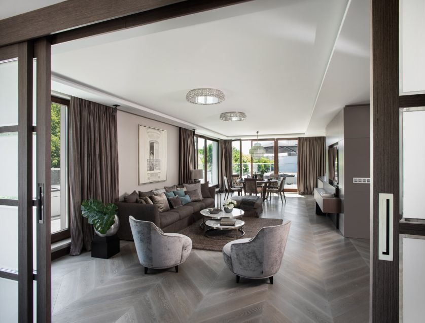 Kryształowe plafony Andromeda od Marchetti w salonie odbijają sączące się przez duże okna naturalne światło.