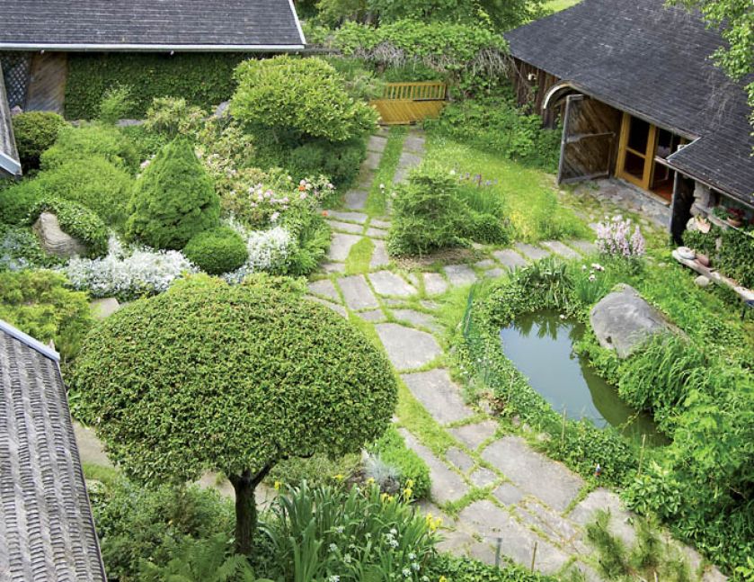 Poszczególne części ogrodu wyznaczają ścieżki: na podjeździe wokół klombu z tujami i jałowcami ułożona została