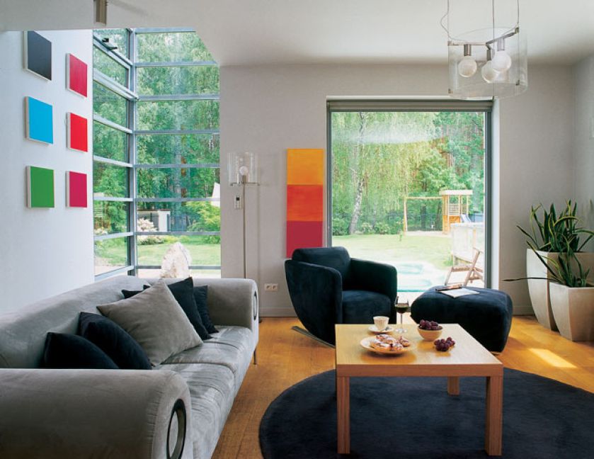 Na ścianach wiszą kolorowe obrazy. Dom otwarty na las