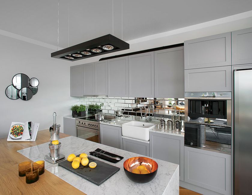 Minimalizm plus lustrzane kafelki i blaty z białego marmuru.